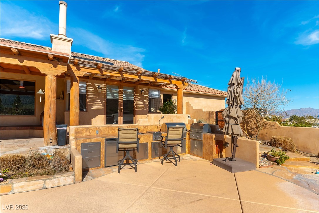 13675 Racel Street Las Vegas, NV 89166 - Photo 37 of 55 View of patio with an outdoor kitchen and a mountain view