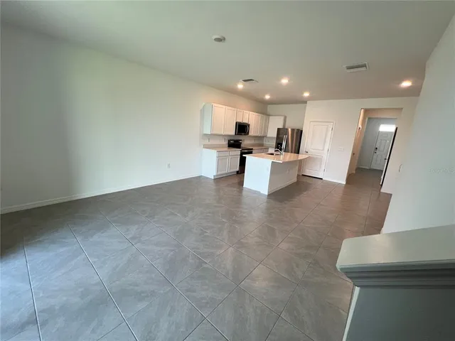 a view of kitchen with kitchen island stainless steel appliances refrigerator sink and stove