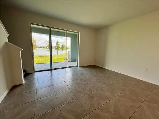 a view of an empty room with a floor to ceiling window and an empty room