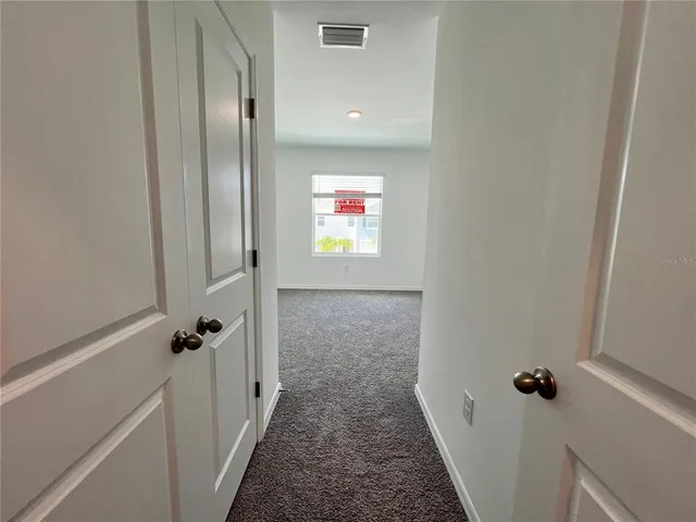 a view of a hallway with closet and wooden floor