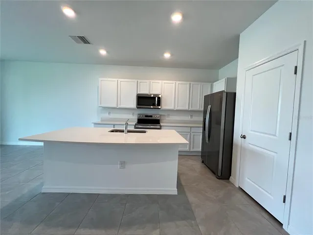 a kitchen with stainless steel appliances a refrigerator sink and microwave