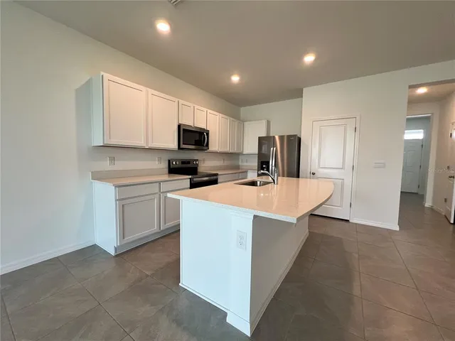 a kitchen with a sink microwave and refrigerator