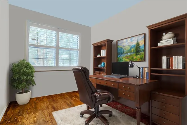 a view of a workspace with furniture and a window