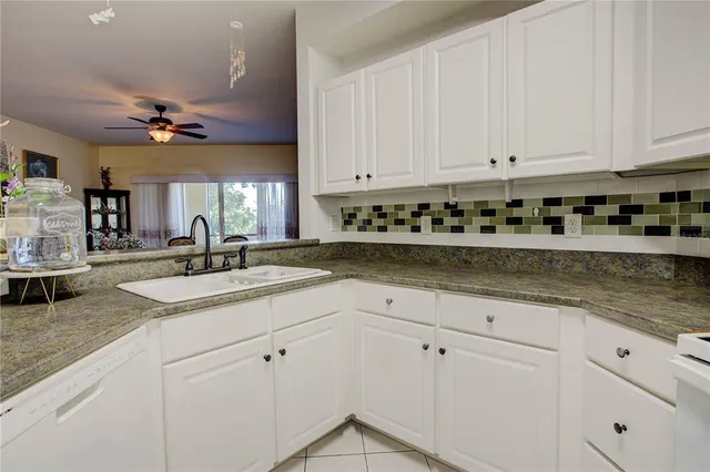 a kitchen with granite countertop a sink a stove and cabinets