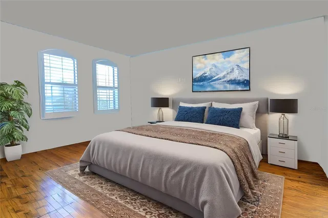 a bedroom with bed and wooden floor