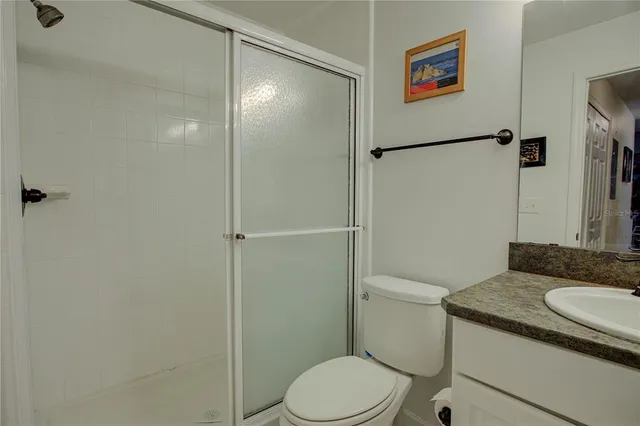 a bathroom with a granite countertop toilet sink and shower