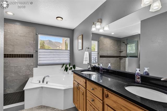 182 Raptor Court Canon City, CO 81212 - Photo 14 of 50 The attached primary bathroom is designed to feel like a relaxing retreat, featuring a large soaker tub, walk-in shower, double vanity, and beautiful countertops that add a touch of elegance.