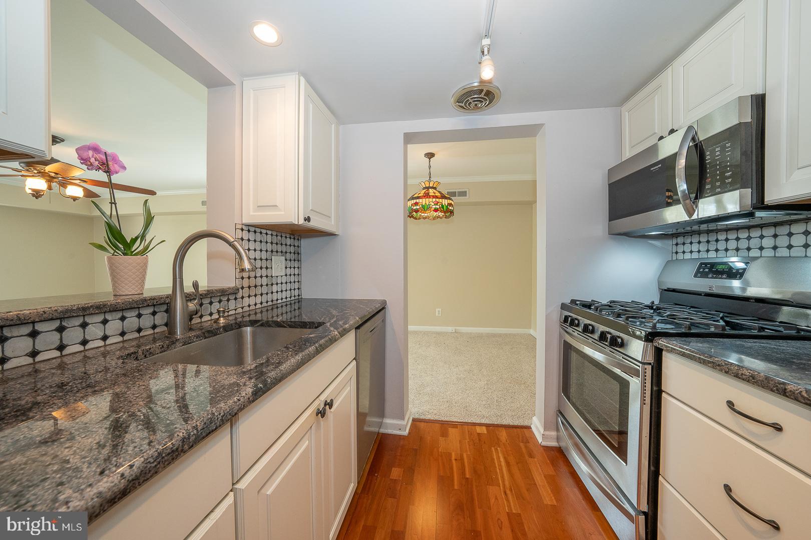 441 Drummers Lane, Unit 441 Wayne, PA 19087 - Photo 15 of 32 a kitchen with granite countertop a sink stainless steel appliances and cabinets