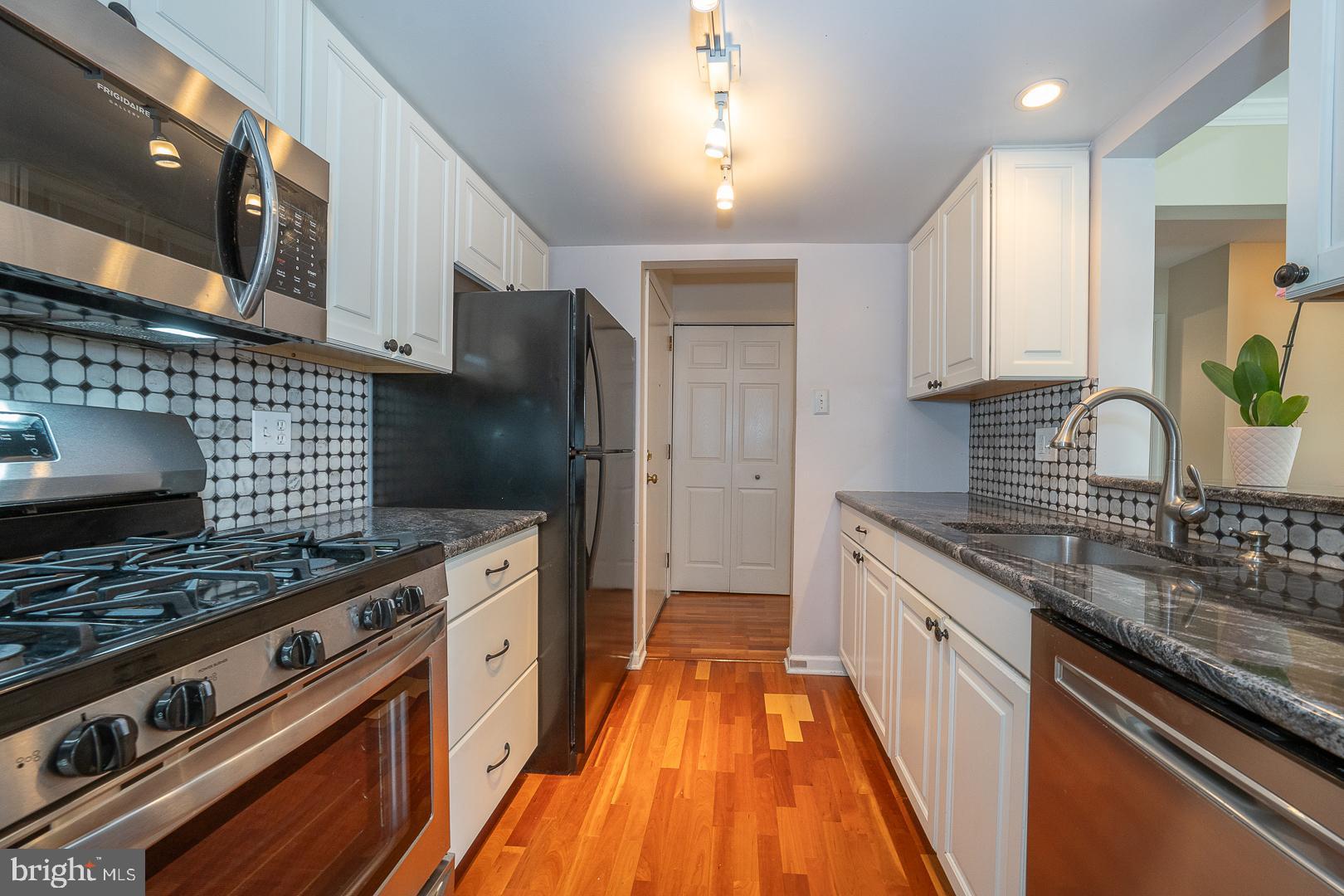 441 Drummers Lane, Unit 441 Wayne, PA 19087 - Photo 17 of 32 a kitchen with stainless steel appliances granite countertop a sink stove and refrigerator
