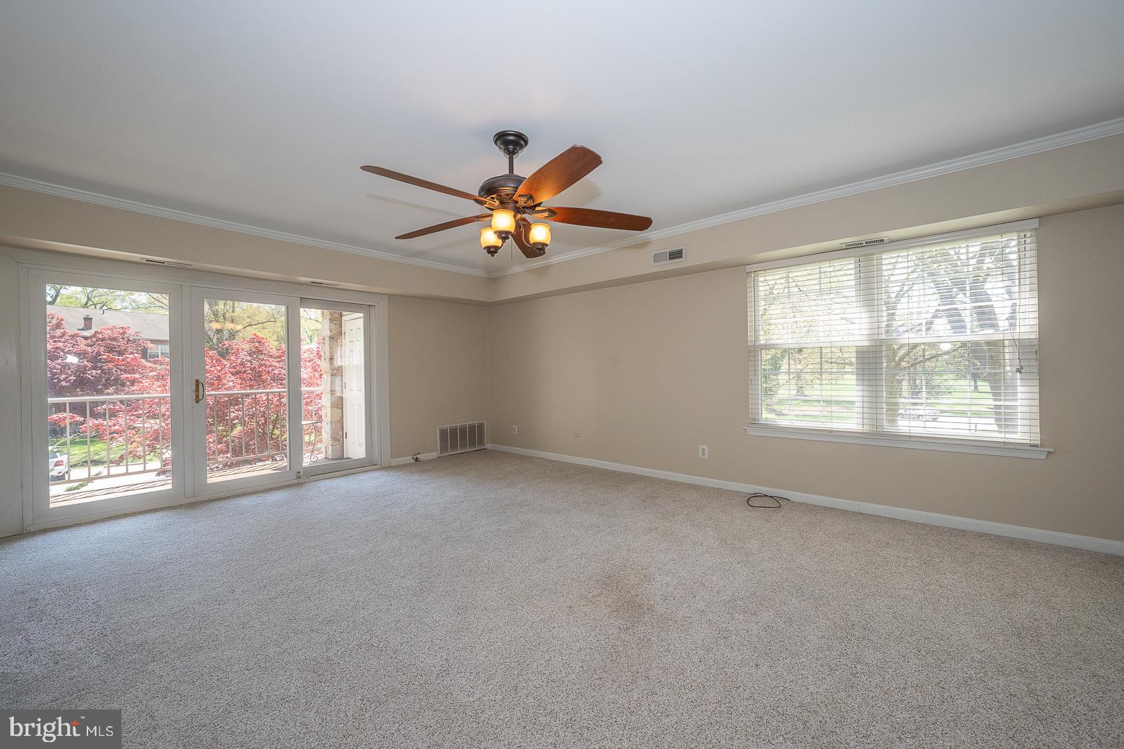 441 Drummers Lane, Unit 441 Wayne, PA 19087 - Photo 9 of 32 an empty room with windows and chandelier fan