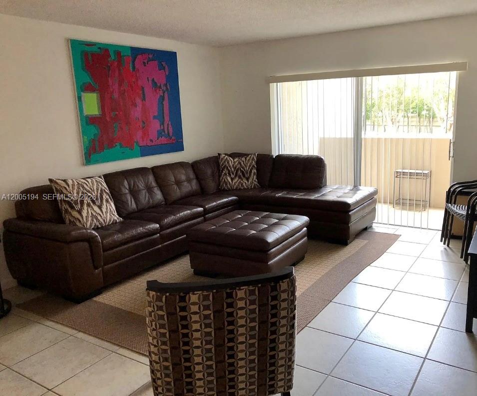 7705 Southwest 86th Street, Unit B211 Miami, FL 33143 - Photo 13 of 22 a living room with furniture and a fireplace