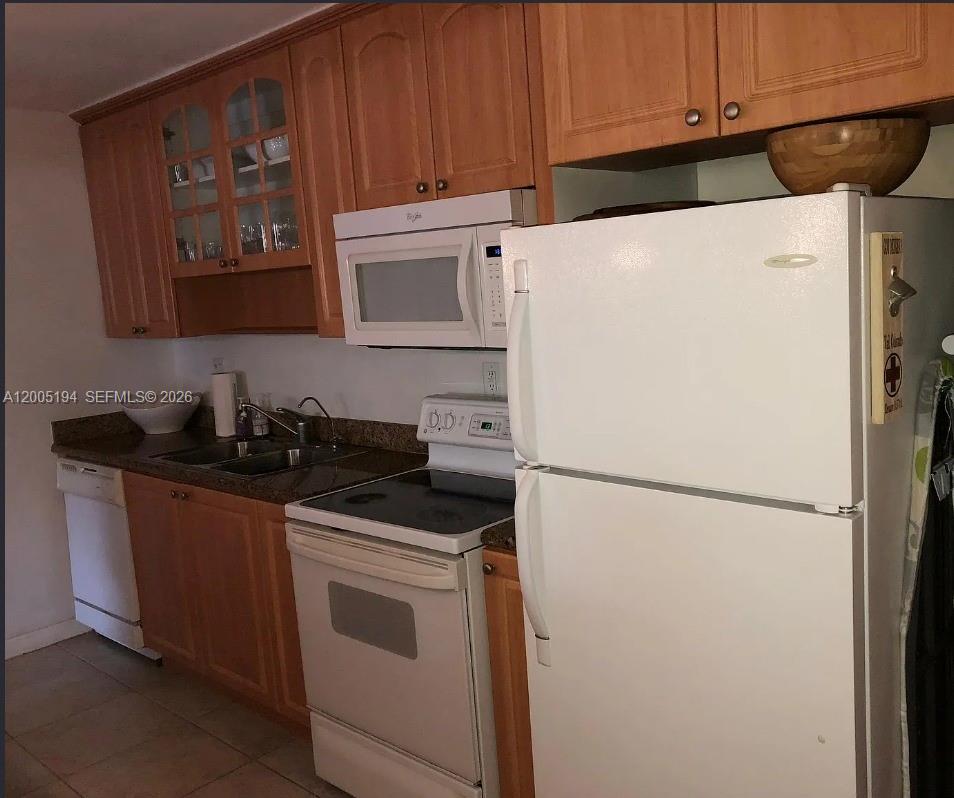 7705 Southwest 86th Street, Unit B211 Miami, FL 33143 - Photo 5 of 22 a white refrigerator freezer and a stove sitting inside of a kitchen