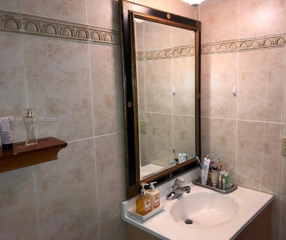 7705 Southwest 86th Street, Unit B211 Miami, FL 33143 - Photo 8 of 22 a bathroom with a sink and a mirror