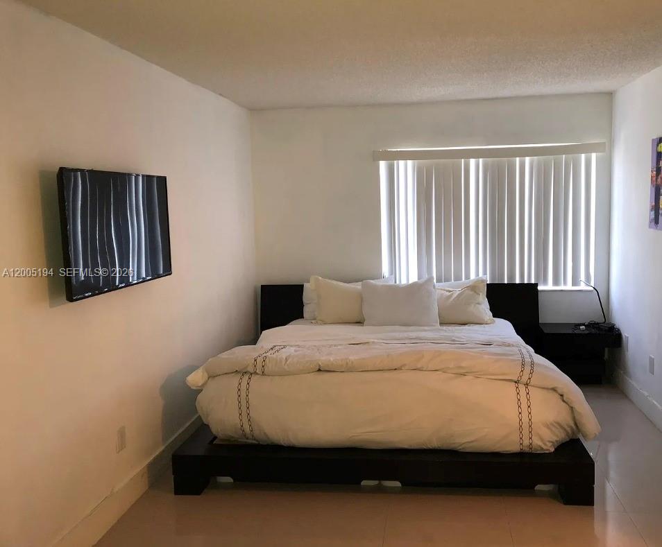 7705 Southwest 86th Street, Unit B211 Miami, FL 33143 - Photo 9 of 22 a bedroom with a bed and window