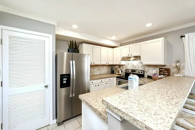 a kitchen with stainless steel appliances granite countertop a sink refrigerator and microwave