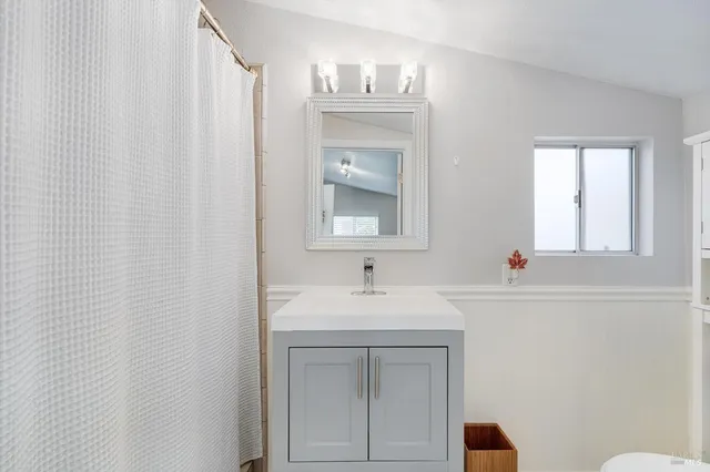 a bathroom with a sink vanity and a mirror