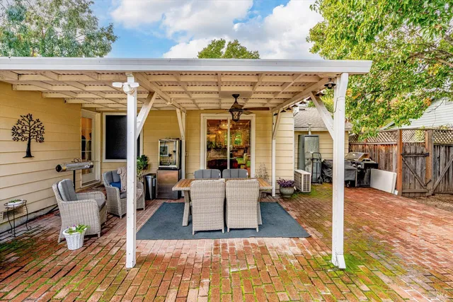 a view of a patio with table and chairs with wooden floor and fence
