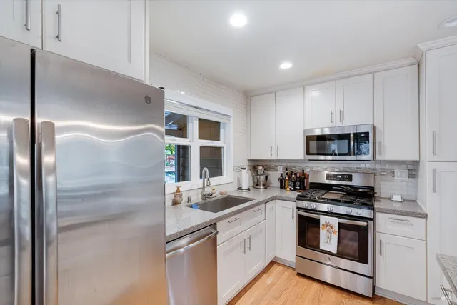 a kitchen with stainless steel appliances granite countertop a refrigerator sink and stove