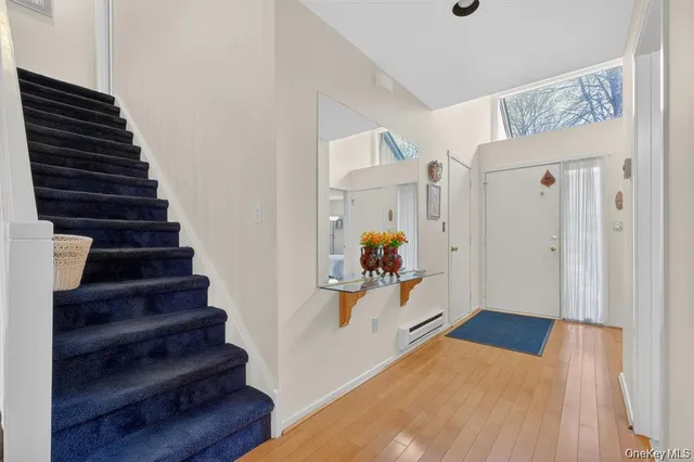 a view of entryway and hall with wooden floor