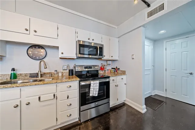 a kitchen with cabinets stainless steel appliances and a window
