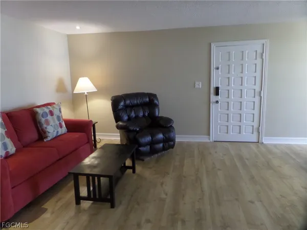 a view of a room with furniture and wooden floor