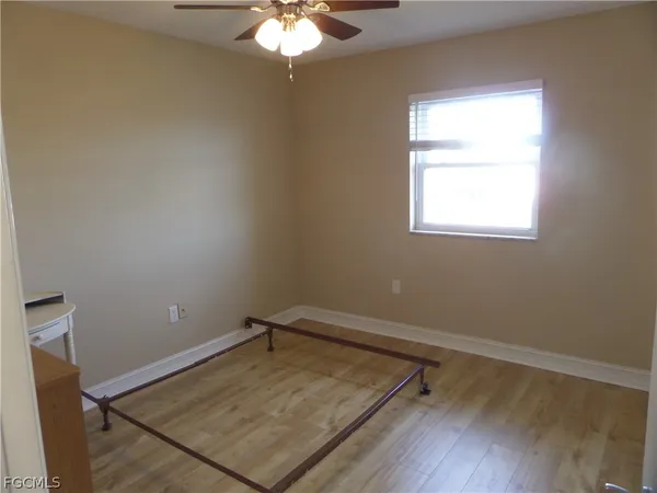 a bedroom with a bed chandelier and a window