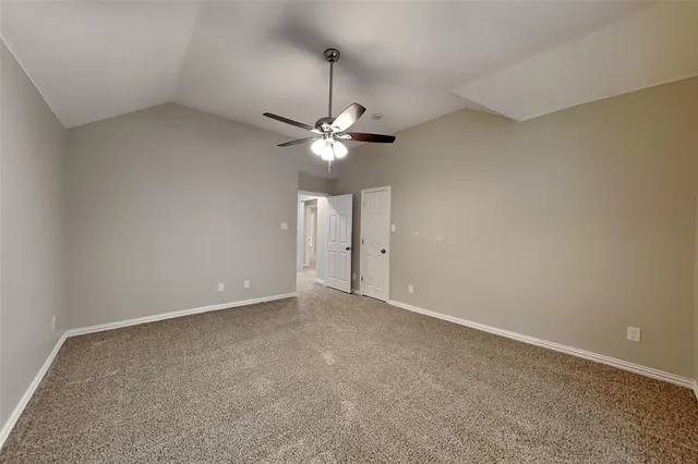 an empty room with a ceiling fan and a window