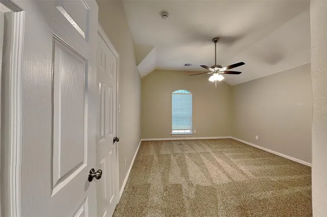 a view of a room with a ceiling fan and window