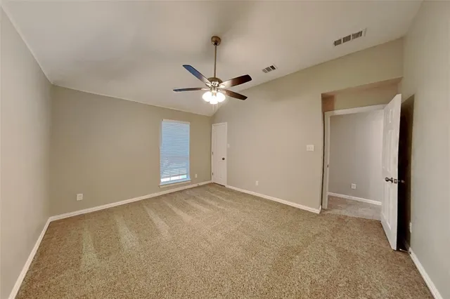 a view of an empty room with a ceiling fan