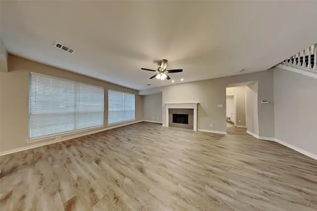a view of empty room with wooden floor and fireplace