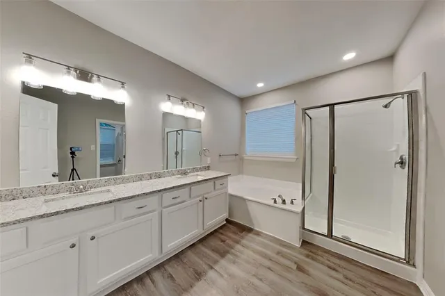 a spacious bathroom with a granite countertop sink mirror and a bathtub