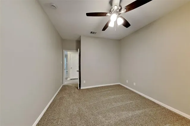 an empty room with chandelier fan