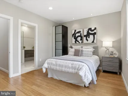 a bedroom with a bed and a flat tv screen on a dresser