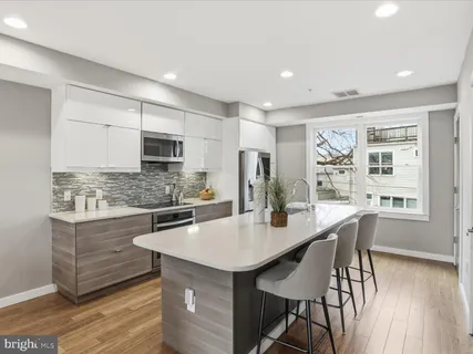 a kitchen with stainless steel appliances a sink stove and cabinets