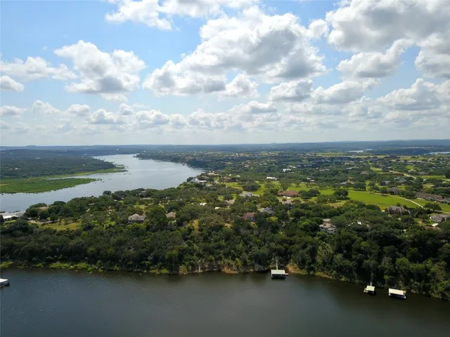 an aerial view of residential houses with outdoor space and lake view