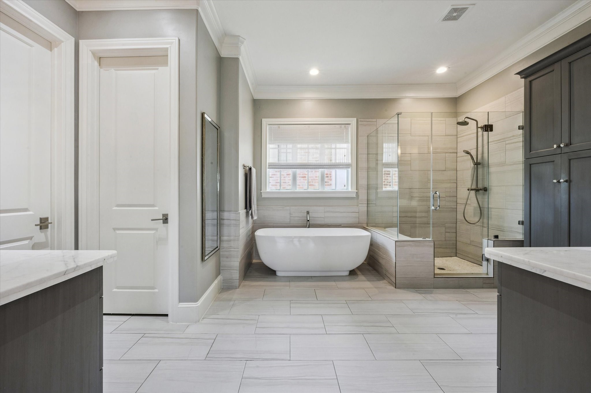 6331 Durford Street Houston, TX 77007 - Photo 22 of 37 The primary bathroom features a water closet, soaking tub, glass enclosed shower, and tile flooring.