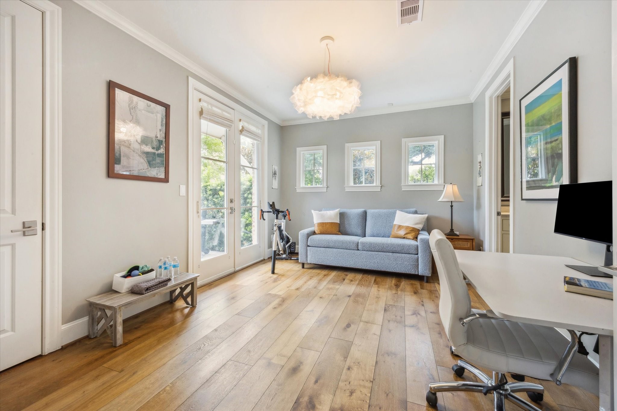6331 Durford Street Houston, TX 77007 - Photo 6 of 37 First floor bedroom features crown molding, chandelier, coat closet, wood flooring, access to side yard and an ensuite bathroom.