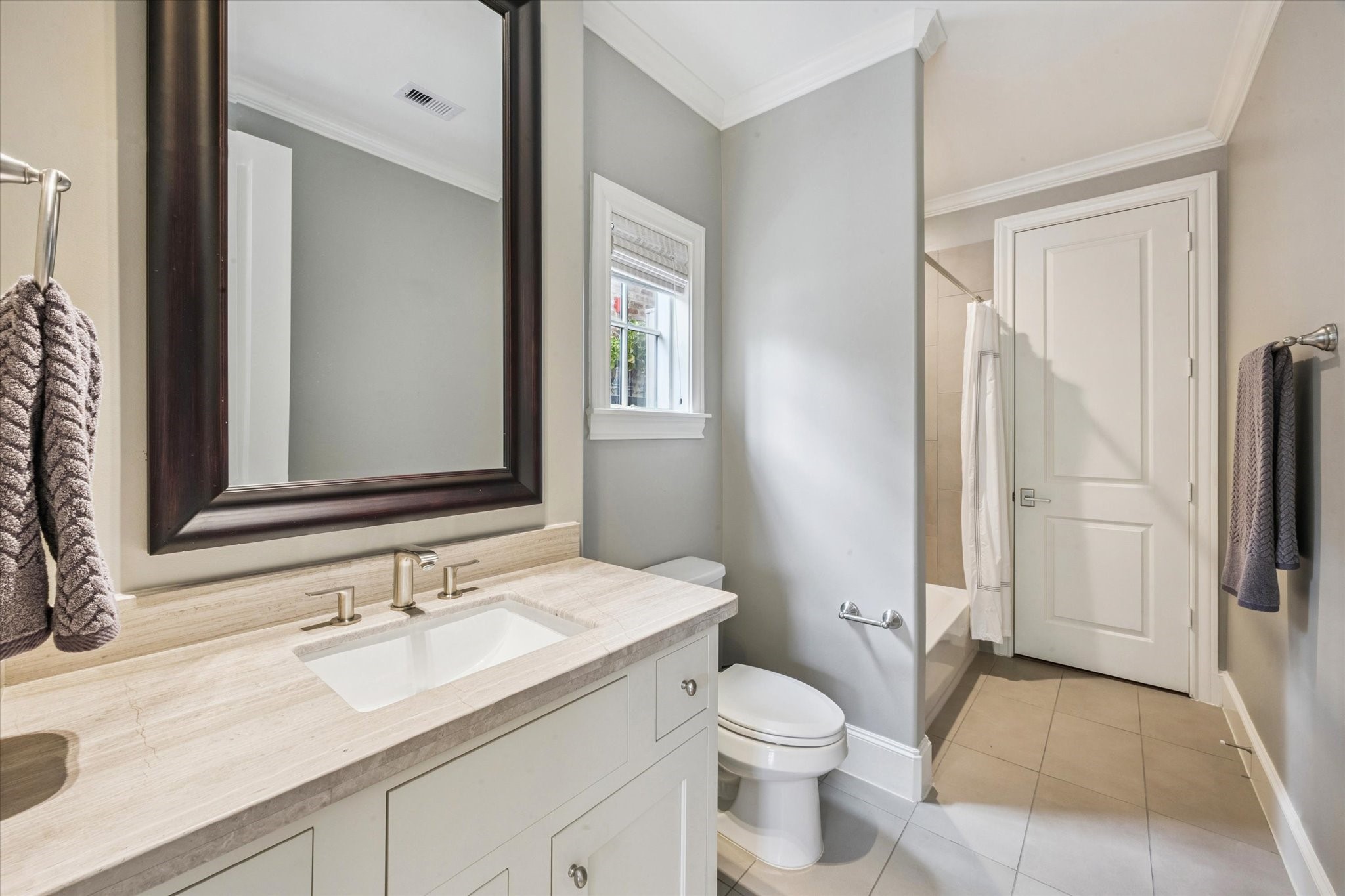 6331 Durford Street Houston, TX 77007 - Photo 7 of 37 First floor guest ensuite bathroom has single vanity with added storage, shower/tub combination, tile flooring, and a walk-in closet.