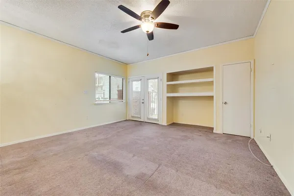 an empty room with a ceiling fan and a window