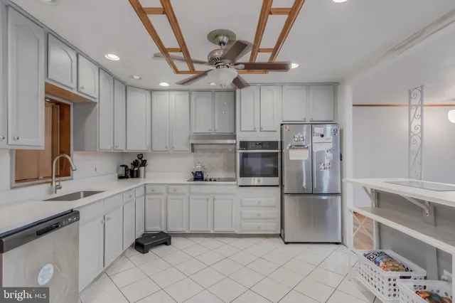 a kitchen with white cabinets and stainless steel appliances