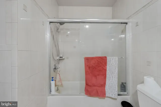 a living room with furniture a flat screen tv and kitchen view