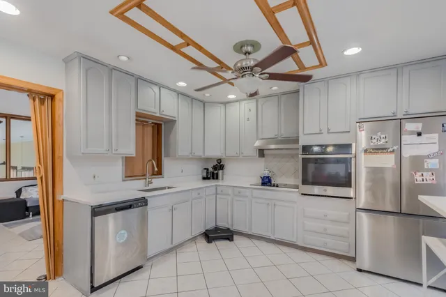 a kitchen with white cabinets and white appliances