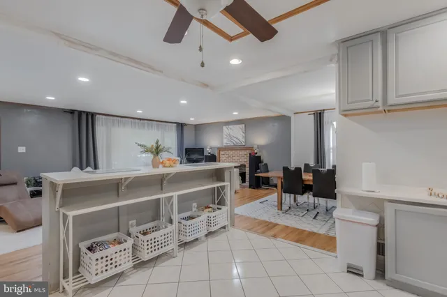 a view of a kitchen with kitchen island a sink stainless steel appliances and cabinets