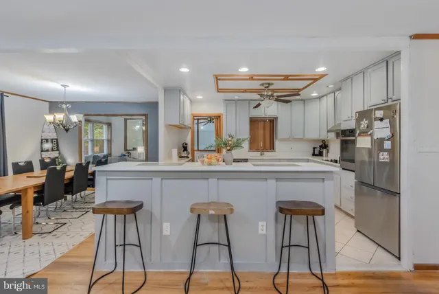 a living room with furniture a fireplace and a chandelier