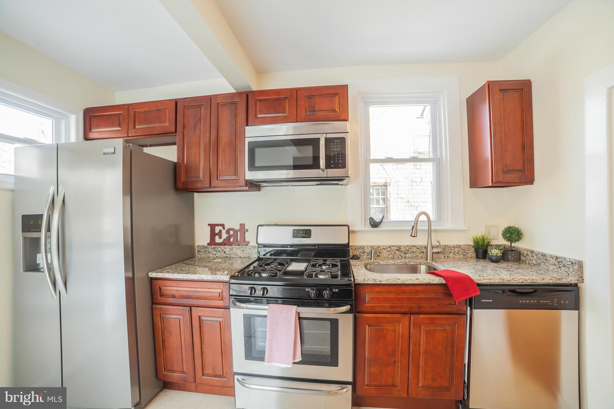 3706 Ferndale Avenue Baltimore, MD 21207 - Photo 12 of 27 a kitchen with stainless steel appliances granite countertop a stove refrigerator sink and microwave