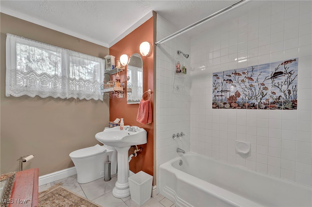 25915 Kennedy Ridge Road North Olmsted, OH 44070 - Photo 20 of 48 Bathroom with shower / bathtub combination, crown molding, light tile patterned floors, and a textured ceiling