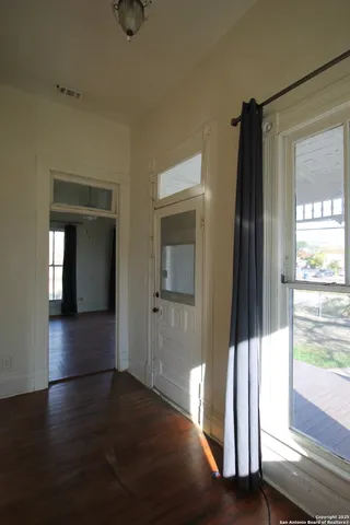 a view of a hallway with wooden floor and door