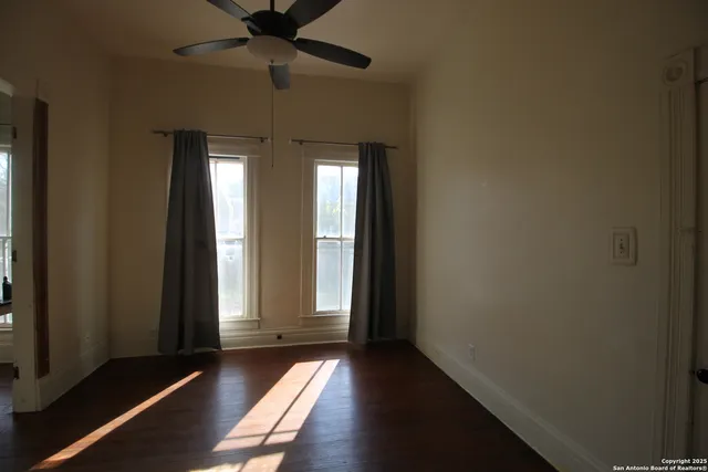 a view of a hallway with wooden floor and a living room