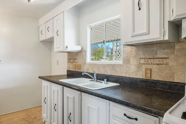 a kitchen with granite countertop a sink a stove and a microwave
