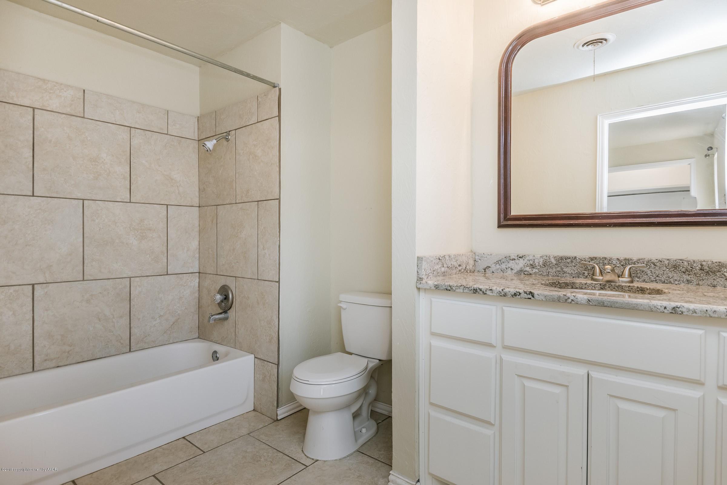 3312 Lombard Road Amarillo, TX 79106 - Photo 16 of 23 a bathroom with a granite countertop sink a toilet and bathtub